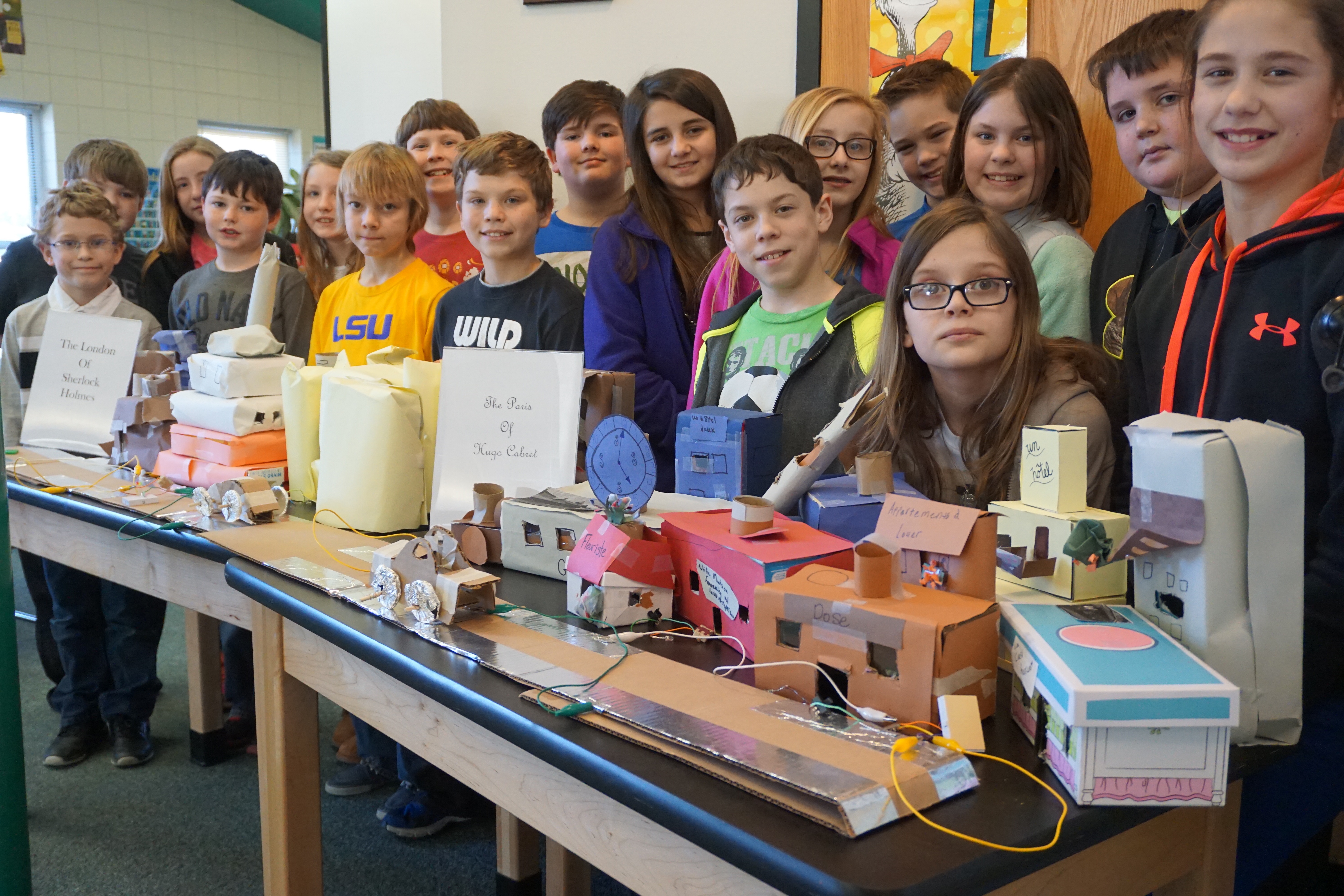 Students pose next to coding projects