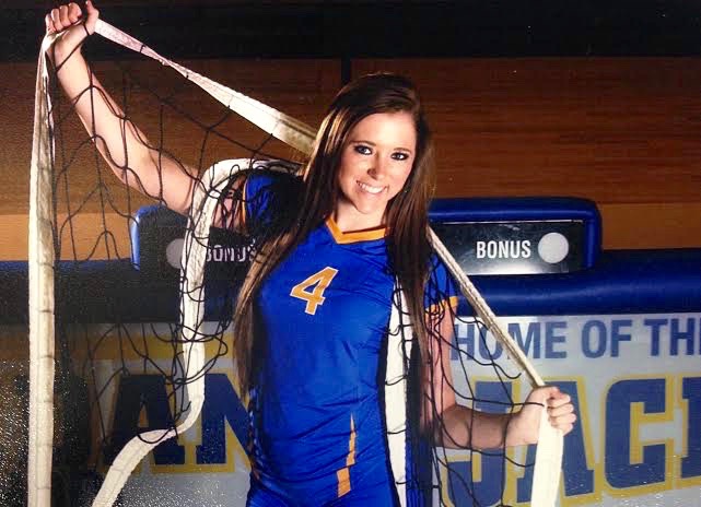 Senior Volleyball Player Sydney Barnett poses with volleyball net