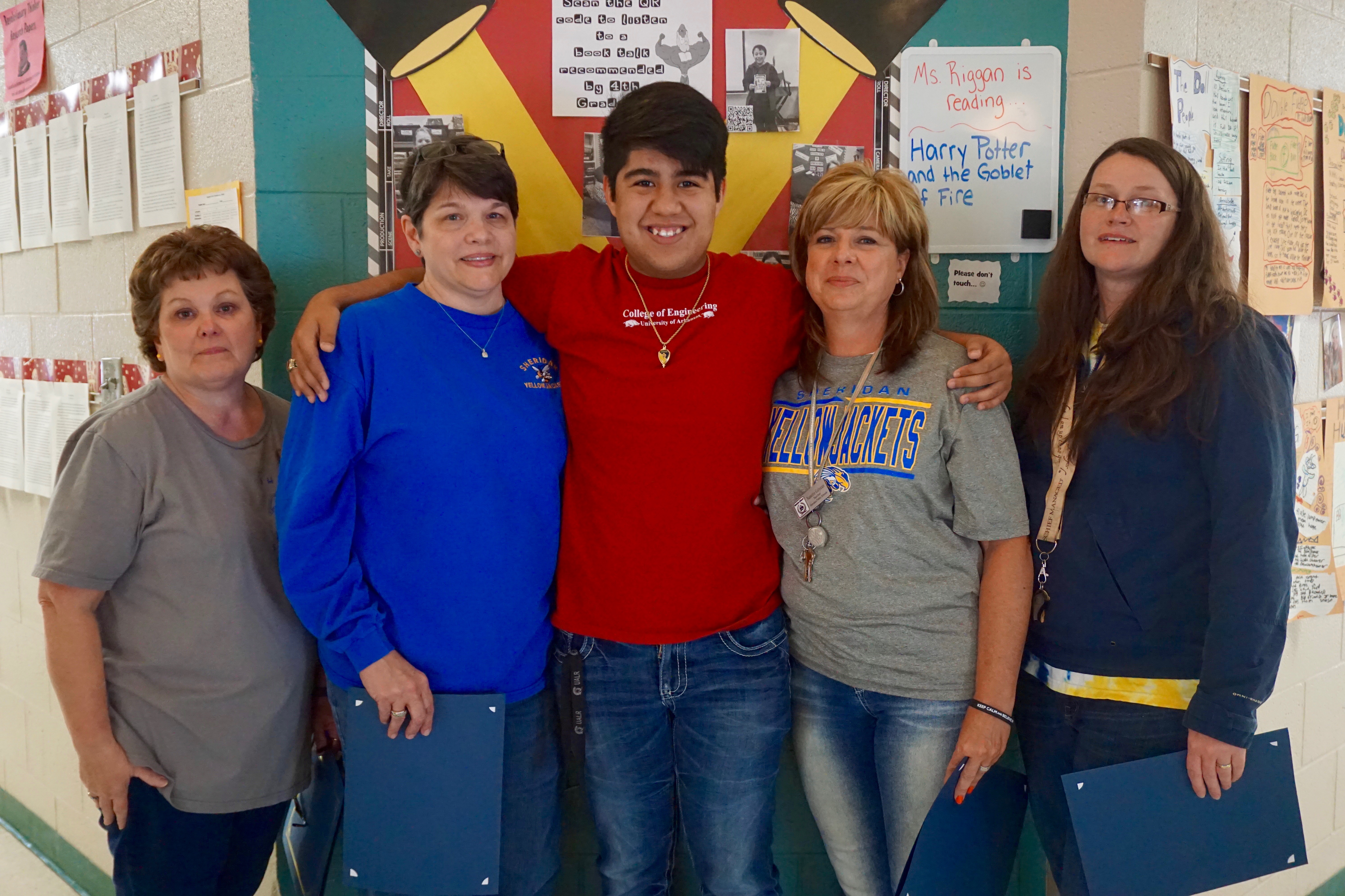 High School Graduate poses with his four impactful teachers