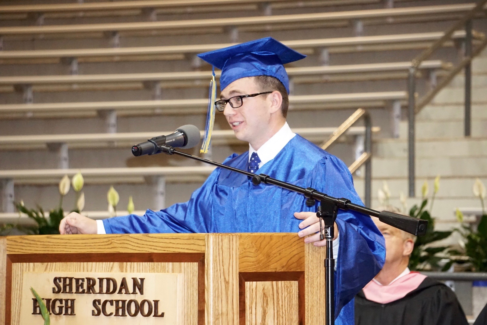 Dylan Thompson giving speech at the podium at graduation
